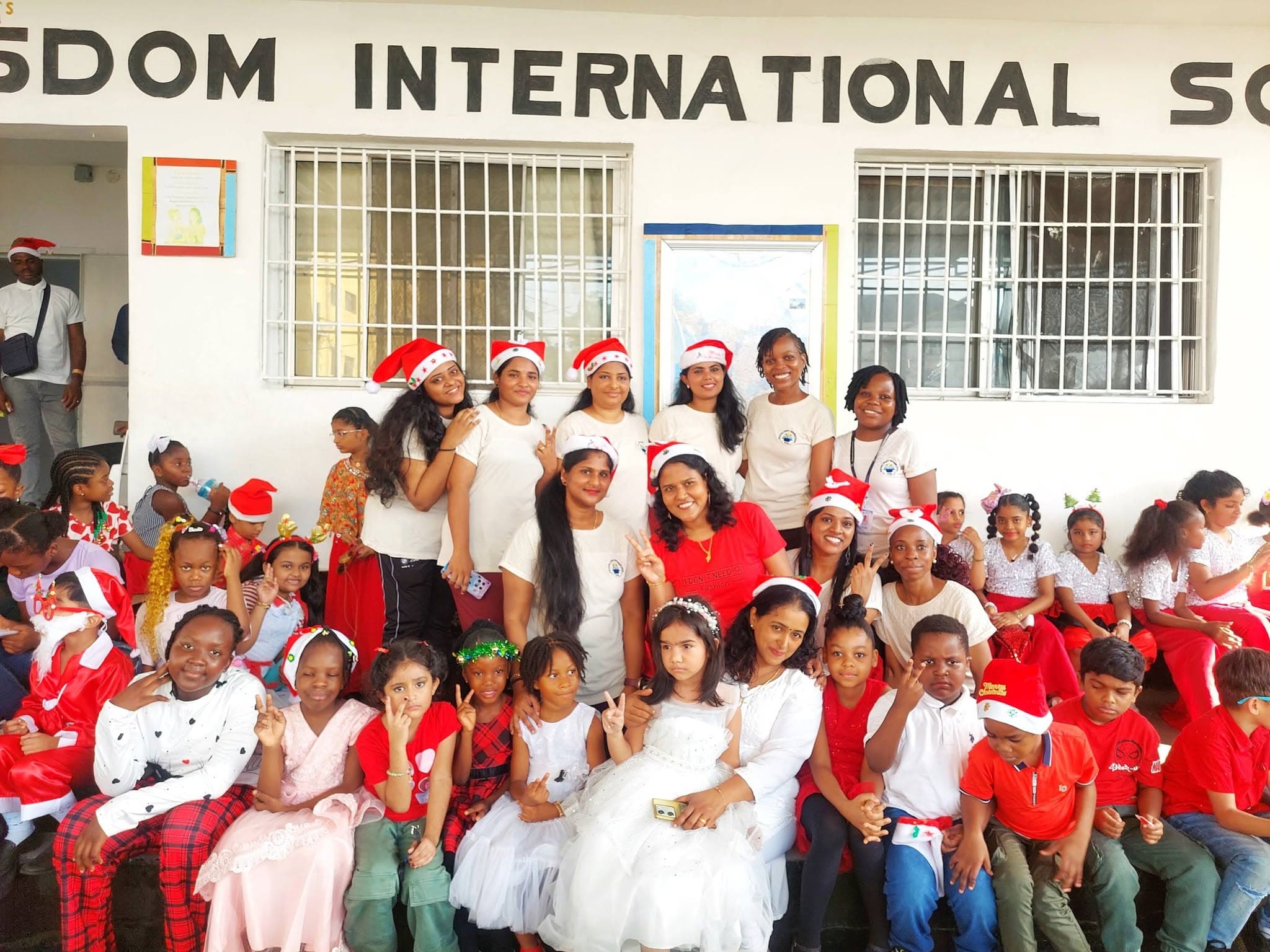 Students and teachers in festive red and white outside the school
