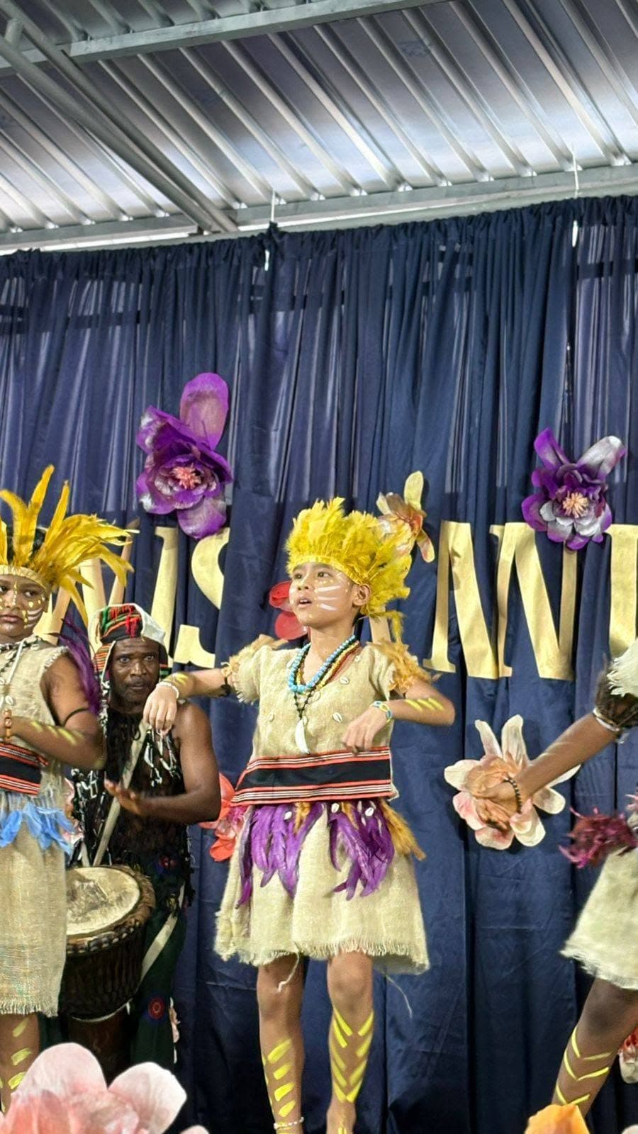 Student performing a traditional dance in a feathered headdress