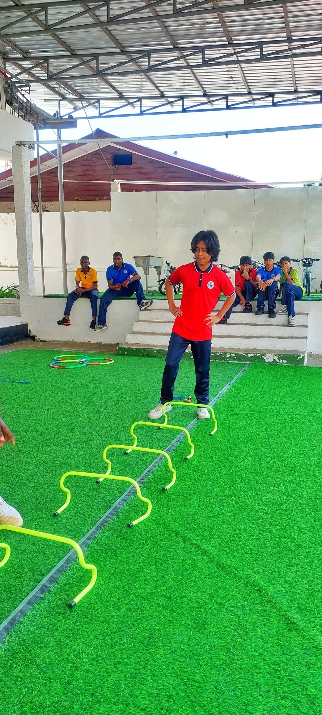 Student completing an agility hurdle drill on the school turf