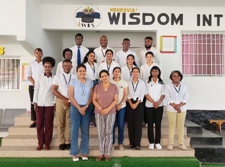 Teachers and staff of Wisdom International School standing together at the school entrance